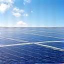 Modern solar panels on a rooftop, gleaming under a clear sky.